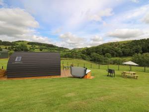 a large yard with a building and a picnic table at Seren in Llandrindod Wells