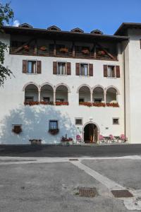 a white building with flowers on the balconies at Dependance Soran-H. San Lorenzo in San Lorenzo in Banale