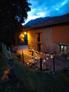 a patio with a table and lights in front of a building at La Casa Nueva Alojamiento Rural in Cereceda