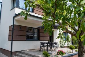 eine Terrasse mit Stühlen und einem Tisch vor einem Haus in der Unterkunft Tempó Apartman Siófok in Siófok