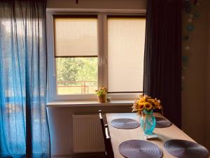 stół z wazą słoneczników w oknie w obiekcie Apartament Wrzos w Dziwnówku
