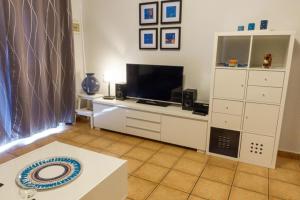 salon z telewizorem i stołem w obiekcie Nicole Playa Park w Puerto del Carmen