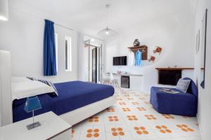 - une chambre avec un lit bleu et un canapé dans l'établissement Estate4home - Niko's apt, à Positano