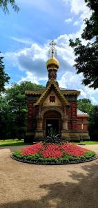 un grand bâtiment avec des fleurs dans un parc dans l'établissement Privat Zimmer in Bad Homburg bei Kurhaus, à Bad Homburg vor der Höhe