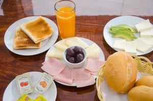 una mesa con platos de comida y un vaso de zumo de naranja en Martinika, en Lima