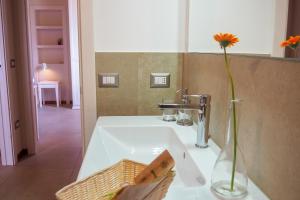 a bathroom sink with a vase with a flower in it at Country House Ca'Balsomino in Urbino +51 photos