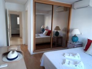 une chambre avec un lit blanc et un grand miroir dans l'établissement MARSOL Beach Apartment, à Vilamoura 14 autres photos
