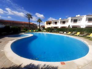 une grande piscine bleue devant un immeuble dans l'établissement MARSOL Beach Apartment, à Vilamoura