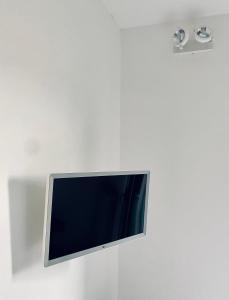 a flat screen tv hanging on a white wall at B&B Blessed apartment in Perugia
