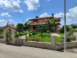 a house with a fence in front of a yard at Villa Ulivi in Filiano