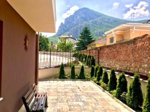 um pátio com um banco e uma parede e árvores em Comfort Luxury Apartments em Vratsa