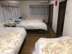 津市にある悠山莊A棟洋室のベッド4台とテーブルが備わる客室です。