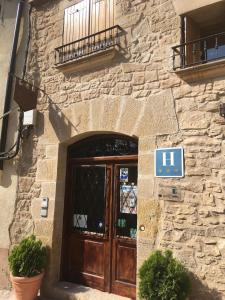 un bâtiment en pierre avec une porte munie d'un panneau. dans l'établissement HOTEL EL CASTELL, à Valderrobres