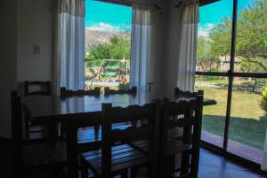 a dining room with a table and chairs and a large window at La Morada in Merlo