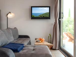 a living room with a couch and a tv on the wall at Ferienhaus Baraka - Medveja in Lovran