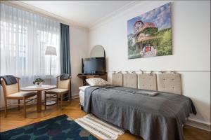 - une chambre avec un lit, une table et une télévision dans l'établissement Bielski Guesthouse, à Gdańsk