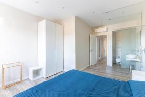 a bedroom with a blue bed and a bathroom at Beachfront Penthouse with private parking in Camaiore