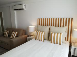 a bedroom with a large bed and a couch at Hotel HS Milfontes Beach - Duna Parque Group in Vila Nova de Milfontes