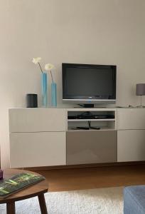 ein Wohnzimmer mit einem TV auf einem weißen Schrank in der Unterkunft Auf der Zschopau-Insel in Zschopau