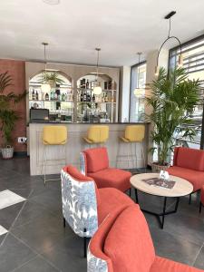 a lobby with chairs and a table and a bar at Soho Boutique Córdoba in Córdoba
