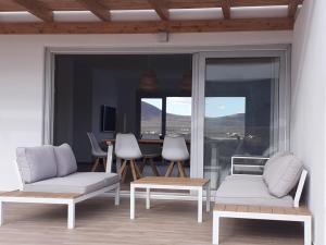 Sala de estar con 2 sofás y mesa en Villa Vista Volcan Lajares with heated pool, en Lajares