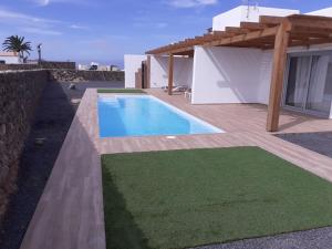 a villa with a swimming pool and a house at Villa Vista Volcan Lajares with heated pool in Lajares