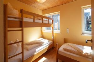 ベツァウにあるSonne Bezau - Familotel Bregenzerwaldの黄色い壁の客室で、二段ベッド2組が備わります。