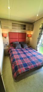 a bedroom with a bed with a red headboard at The Hideaway in Grange Over Sands