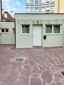 a house with a white door and a stone driveway at MAISON MY LIFE in Bolzano