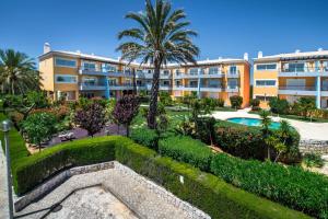 an apartment building with a pool and palm trees at Foz da Ria in Lagos