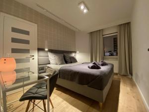a bedroom with a bed and a glass table at Apartament Opieszyn 16 in Września