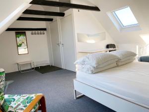 een slaapkamer met een wit bed in een kamer bij Holiday rooms Rudkøbing in Rudkøbing