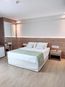 a bedroom with a large white bed in a room at Condominio Vista azul Flat-Hotel in Pedra Azul