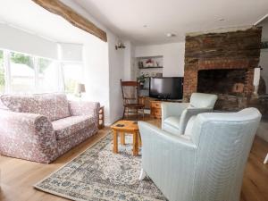 a living room with a couch and chairs and a tv at Kerslake Cottage in Bodmin