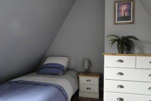 a bedroom with a bed and a dresser at La bergerie, cottage normand 5 pers. avec piano in Épreville-en-Lieuvin
