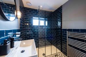 a bathroom with blue tiled walls and a sink at Luxury Blackpool Apartments by Sasco in Blackpool