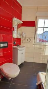 a red bathroom with a toilet and a sink at Hotel Blagaj Mostar in Blagaj