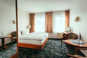 een hotelkamer met een bed en een tafel bij Landhotel Classic in Wensickendorf