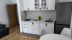 a small kitchen with white cabinets and a sink at Apartman Jelena Sokobanja in Soko Banja