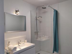 een witte badkamer met een wastafel en een douche bij Appart'HomeCity - Rouen Grand Prieuré in Rouen +19 foto's