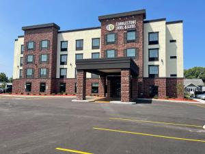a building with a parking lot in front of it at Cobblestone Hotel & Suites - Little Chute in Little Chute
