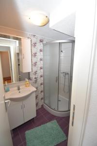 a bathroom with a sink and a glass shower at Apartmani Mihaela in Šibenik