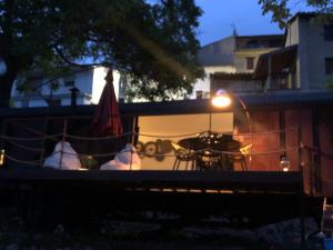 a patio with a table and a umbrella at night at Vagón Orient Express - Housevanlive in Casas Altas