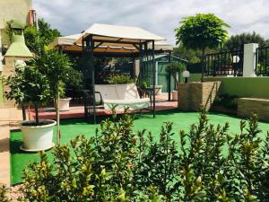 a garden with green grass and a gazebo at B&B La Dea Hestia in Bosa