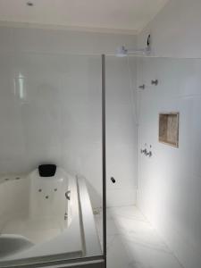 a white room with a glass case in a room at Pousada Escarpas in Capitólio