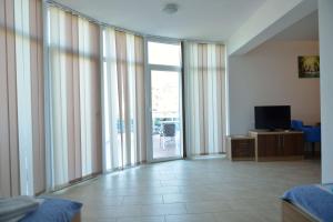 sala de estar con puertas correderas de cristal y TV en Belvedere Apartments with Seaview, en Dobra Voda