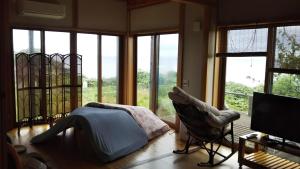 a bedroom with windows and a bed and a television at Nihonkai Nou no yado Miharashitei - Vacation STAY 11631 in Itoigawa