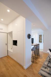 a white kitchen with white cabinets and a dining room at Luxury apartment Mirage Split in Split