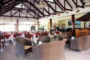 een eetkamer met tafels en stoelen in een restaurant bij Pirogue Lodge in Baie Sainte Anne