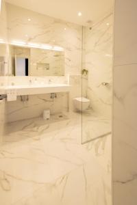 a white bathroom with a shower and a sink at Luxury apartment Mirage Split in Split